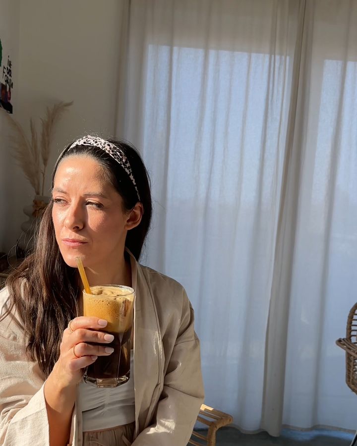 Angelique mit Iced Coffee am sonnigen Fenster