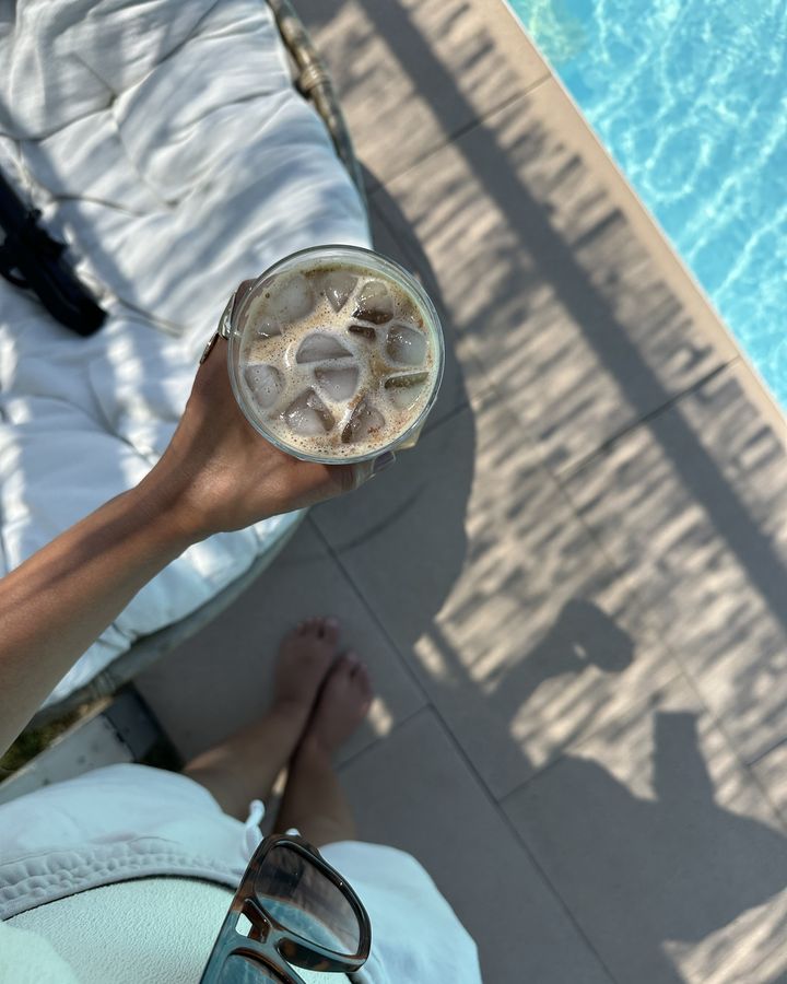 Eiskaffee in der Hand am Pool, von oben